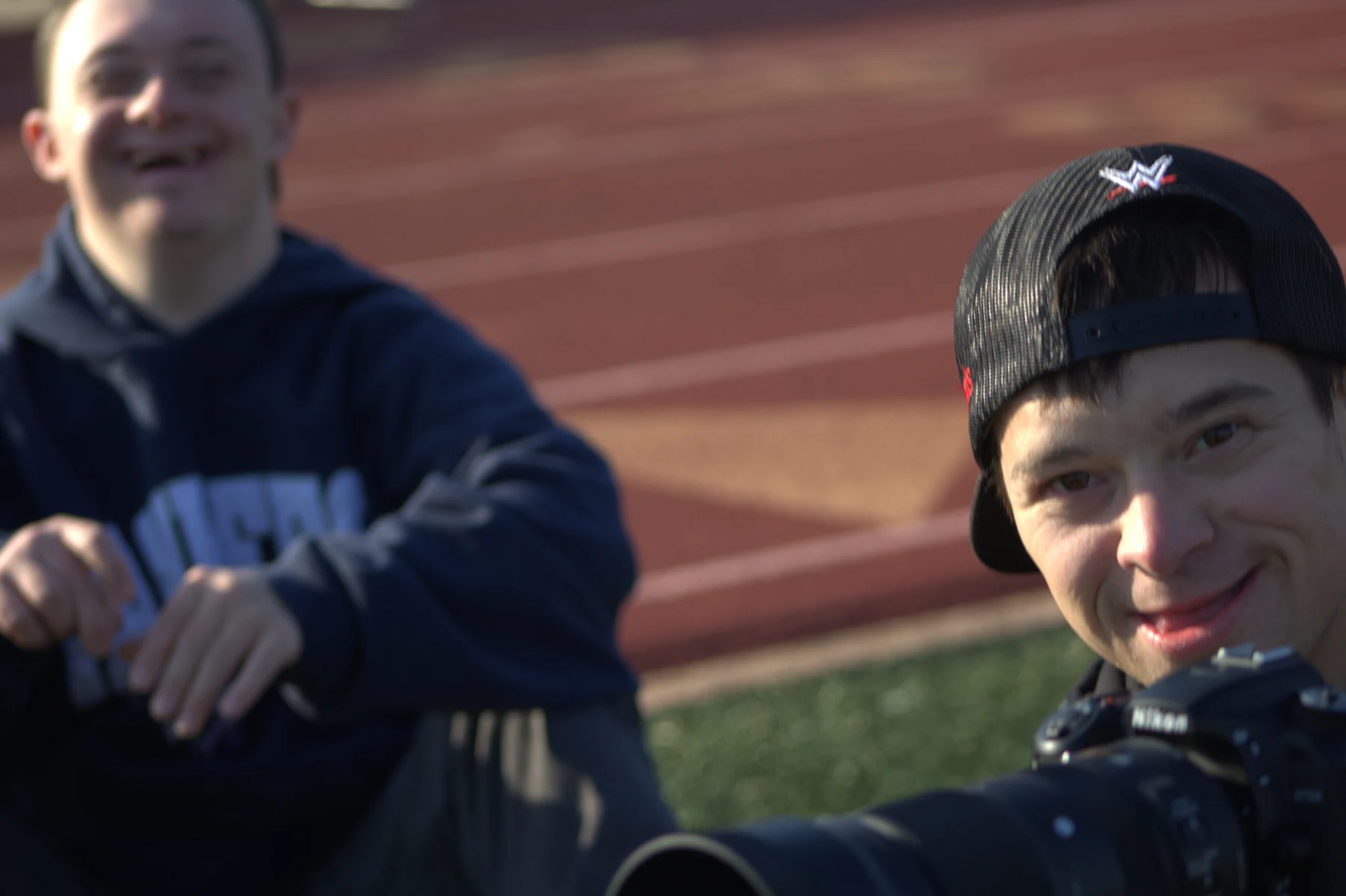 David and a friend enjoying a moment together behind a camera at the track